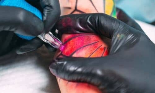 tatuatrice che effettua un tatuaggio realistico su cliente